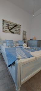 a white bed with blue sheets and blue pillows at Symi . VILLA CALME (Sur la Mer). in Symi