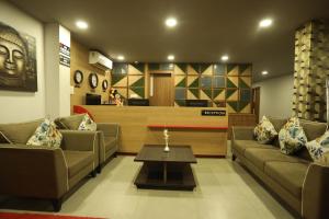 a living room with two couches and a coffee table at VIPs Hotel Olive in Siliguri