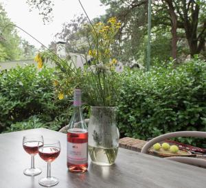 een fles wijn en twee glazen op een tafel bij Vakantiepark Zevenbergen in Heesch