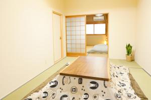 una sala de estar con una mesa en el centro en HAT Koizumi, near from JR Koizumi station 大和小泉駅徒歩2分の貸切一軒家 en Koizumi