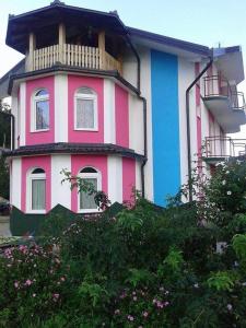 un edificio rosa azul y blanco con balcón en Vila Anđelija en Velika Kladuša
