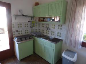 a small kitchen with green cabinets and a sink at GEORGES IPSOS APARTMENTS in Ipsos +7 photos