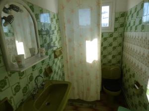 La salle de bains est pourvue d'un lavabo, de toilettes et d'une fenêtre. dans l'établissement GEORGES IPSOS APARTMENTS, à Ýpsos