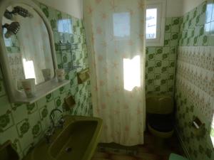 a bathroom with a sink and a toilet and a window at GEORGES IPSOS APARTMENTS in Ipsos