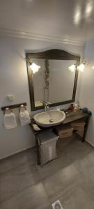 a bathroom with a sink and a mirror at Symi . VILLA CALME (Sur la Mer). in Symi