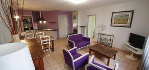 ヴィルフランシュ・ド・ルエルグにあるGite Pagoのリビングルーム(紫色の椅子、テレビ付)