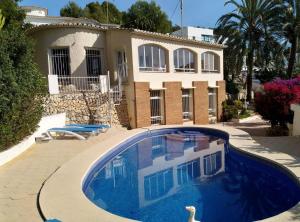 uma casa com piscina em frente a uma casa em Marina em Benissa