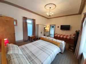 a hotel room with two beds and a television at Caulfields Hotel in Burry Port