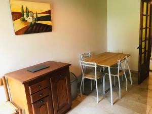 a room with a table and chairs and a painting at gite Le Verdier in Nailhac