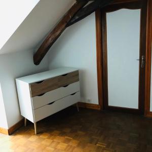 - une commode blanche dans une chambre mansardée dans l'établissement gite Le Verdier, à Nailhac