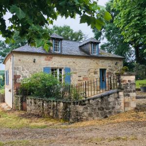 an old stone house with a stone wall at gite Le Verdier in Nailhac