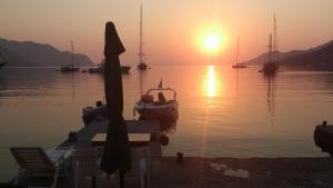 einen Sonnenuntergang über einem Wasserkörper mit Booten in der Unterkunft Symi . VILLA CALME (Sur la Mer). in Symi