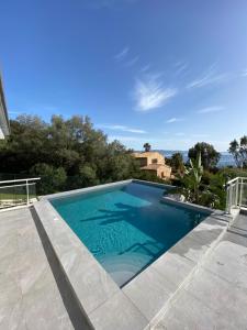 uma piscina numa villa com água azul em Le Loft em Ajaccio