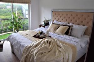 a bedroom with a large bed with a large window at Lake Infinity Luxury Condos in Nuwara Eliya +57 photos