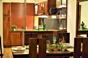 a dining room with a table and a kitchen at Lake Infinity Luxury Condos in Nuwara Eliya