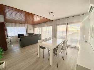 una sala da pranzo con tavolo e sedie bianchi di Apartamento Tossa de Mar a Tossa de Mar