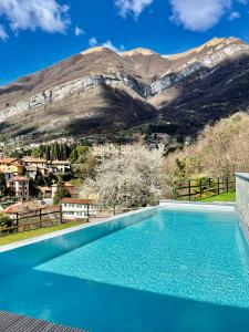 a swimming pool with a mountain in the background at La Filanda di Viano in Villa in Tremezzo