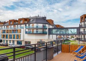 Un balcón con dos sillas y un edificio. en Bel Mare 405, en Międzyzdroje