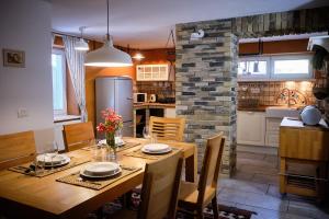 Il comprend une cuisine et une salle à manger avec une table et des chaises en bois. dans l'établissement Apartments Koledniki, à Bled