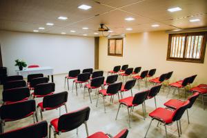 an empty room with red chairs and a whiteboard at Hotel Che Roga in Puerto Eldorado
