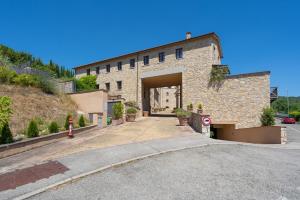 duży kamienny budynek z dużym garażem w obiekcie Borgo di Gaiole - Casa BD - apartment with a view & travel guide w mieście Gaiole in Chianti