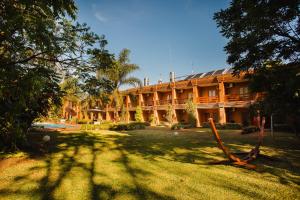 Puerto Eldorado的住宿－Hotel Che Roga，前面有树木的大建筑