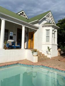 a house with a swimming pool in front of a house at Heath Villa - private room in Port Elizabeth