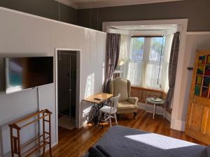 uma sala de estar com uma mesa e uma cadeira em Heath Villa - private room em Port Elizabeth