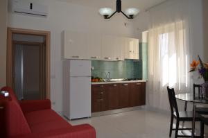 a living room with a red couch and a kitchen at Case Maiori in Maiori +15 photos