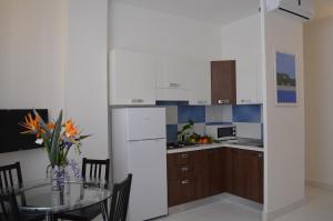 a kitchen with a table and a white refrigerator at Case Maiori in Maiori