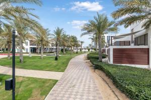 a walkway in front of a building with palm trees at FAM Living - Sarai Beach Villas - Palm Jumeirah - Families Only in Dubai