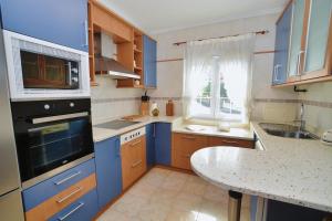 a kitchen with blue cabinets and a table in it at Apartamento Ama - 5828 in Isla
