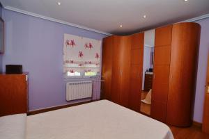 a bedroom with a bed and wooden cabinets at Apartamento Ama - 5828 in Isla
