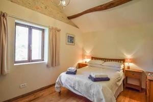 a bedroom with a bed and a desk and a window at La Vieille Fromagerie in Brux +59 photos