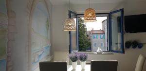 a dining room with two chandeliers and a window at Koper Center Apartment in Koper