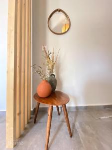 a table with an orange and a vase on it at Theros Lux Apts. in Planos