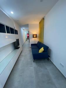 グジラにあるGzira two-bedroom Apartmentのリビングルーム(青いソファ、黄色い枕付)