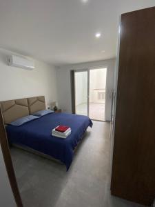 een slaapkamer met een bed met een blauw dekbed bij Gzira two-bedroom Apartment in Il-Gżira