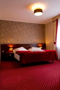 a hotel room with a bed and a red carpet at Hotel TiM in Cekanowo
