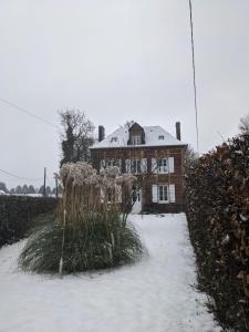 a house with snow on the ground in front of it at Numéro 7 in Le Tronquay