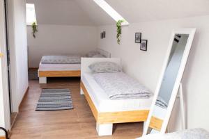 2 Betten in einem Zimmer mit Spiegel in der Unterkunft apartman UNO in Jajce