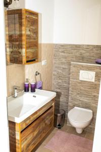 apartman UNO في يايتشه: حمام مع حوض أبيض ومرحاض