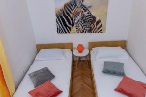 2 camas en una habitación con una foto de una cebra en Apartman Duce Milka, en Duće