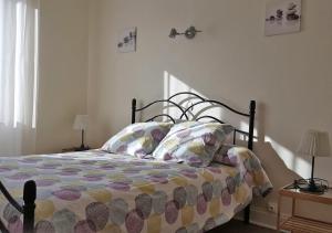 um quarto com uma cama com um edredão e 2 candeeiros em GÎTE GUERY em Chambon-sur-Lac