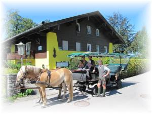 eine Gruppe von Personen, die in einer Pferdekutsche reiten in der Unterkunft Ferienwohnungen Landhaus Gerum in St. Wolfgang