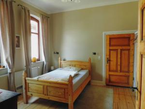 1 dormitorio con cama de madera y puerta de madera en Charmante Dorfschule, en Hohenhameln