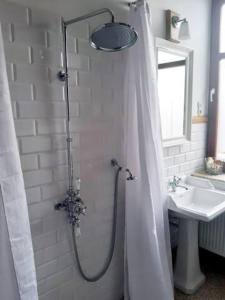um chuveiro com uma cortina de chuveiro ao lado de um lavatório em Charmante Dorfschule em Hohenhameln