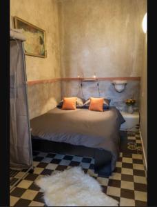 1 dormitorio con 1 cama con almohadas de color naranja en La chapelle de Melin, en Auxey-Duresses