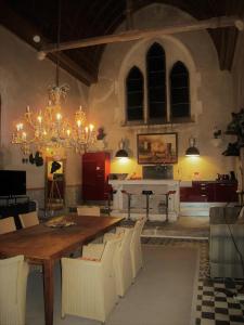 comedor con mesa, sillas y lámpara de araña en La chapelle de Melin, en Auxey-Duresses