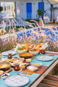 une table avec des assiettes et des bols de nourriture dans l'établissement Rhodium Hotel Alaçatı, à Alaçatı